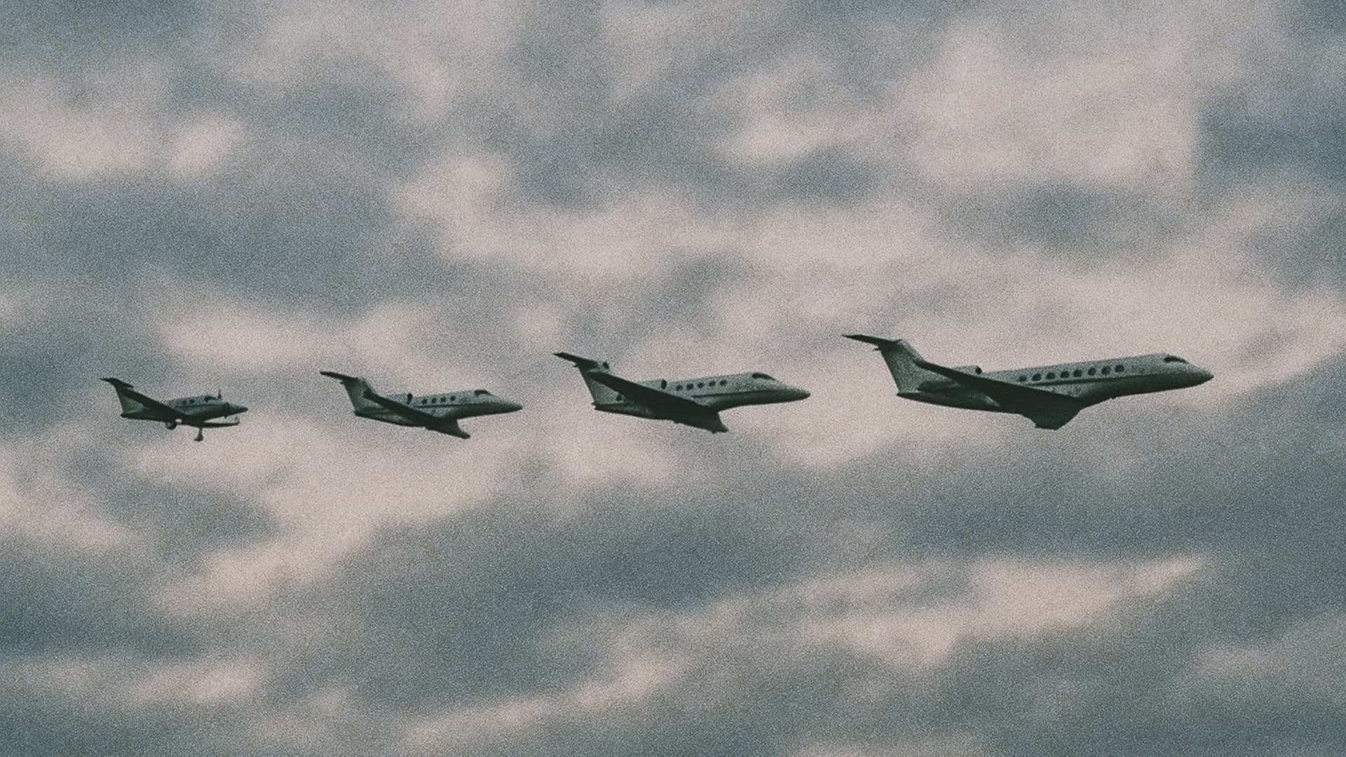 A formation of four planes flying closely together against a clear blue sky.